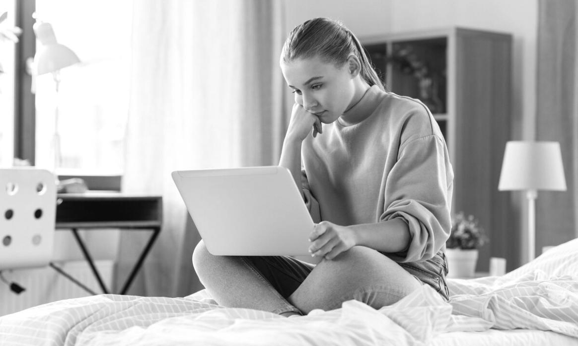 Personne analysant des données financières avec une calculatrice et des graphiques de marché